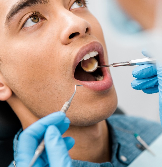 Facial closeup of man with brown eyes undergoing dental exam