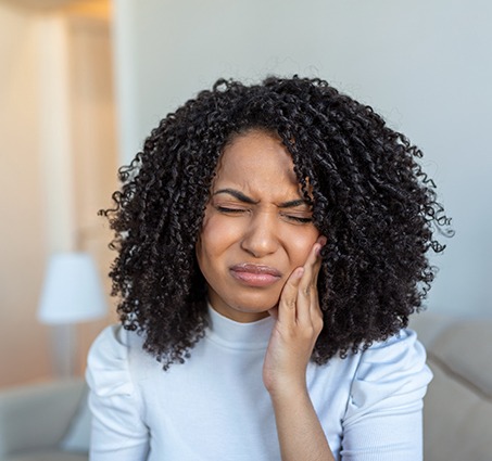 Woman rubbing her jaw in pain