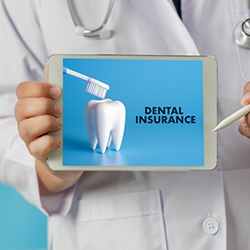 Dentist holding tablet showing a graphic that reads Dental Insurance